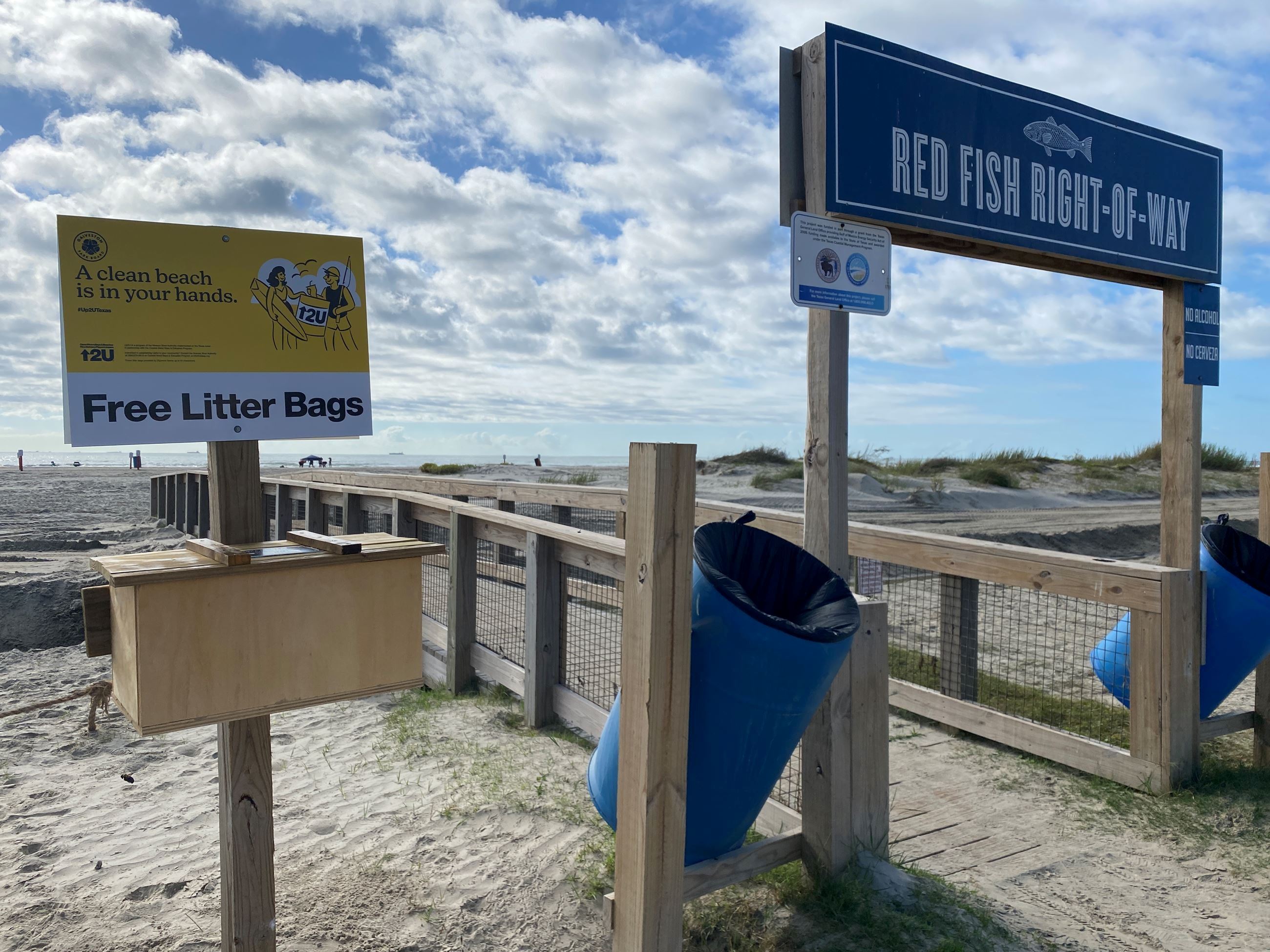 Wooden box on a pole at the beach with yellow Up2U sign 