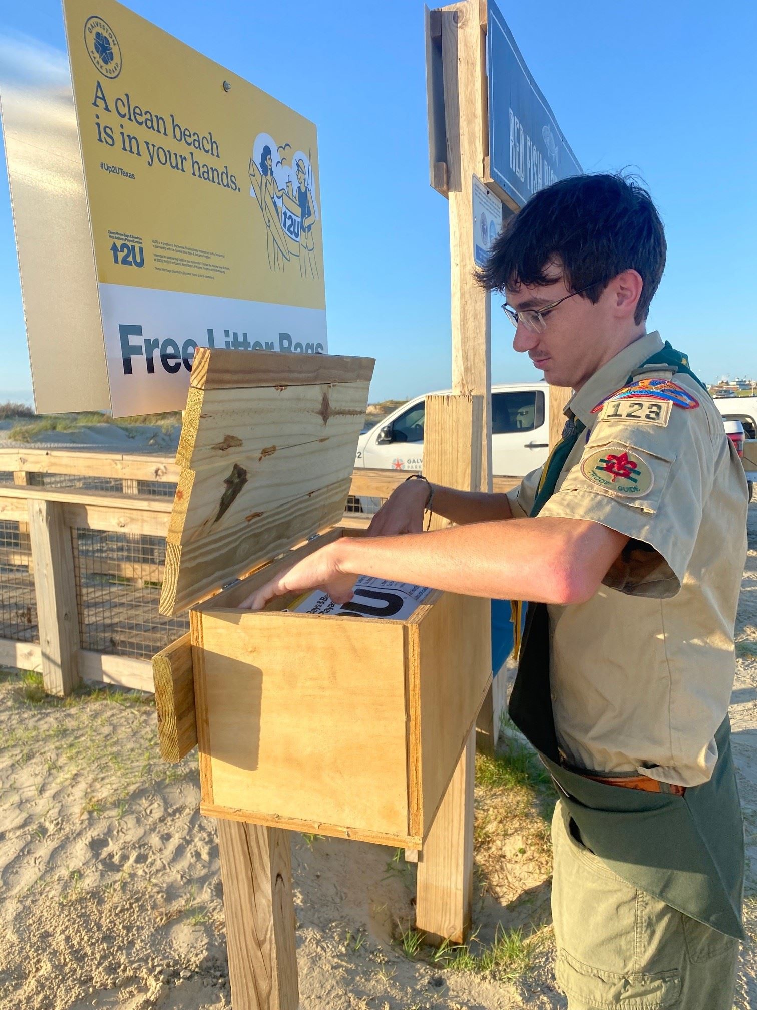 Boy filling wooden box with trash bags